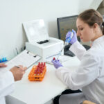 Laboratory Staff Competency Assessment: Meeting CLIA Requirements Year-Round Why Year-Round Compliance Beats Last-Minute Scrambling Competency assessment has remained one of the top deficiencies in laboratory inspections for over two decades. CAP data shows it held the number one spot from 2018 through 2020, and it remained in the top four deficiencies through 2022 and 2023 with 644 citations. In 2021, nearly one in five laboratories surveyed by CMS received a competency-related citation. These numbers tell a clear story: laboratories are still struggling with requirements that have been in place since 1988. At Laboratory Management Consultants, we see laboratories deal with this struggle all the time. Operating with incomplete documentation, missing assessment windows, or unqualified assessors realizing they have a problem only when a surveyor walks through the door. At that point, what should have been a routine compliance function becomes an expensive emergency. In this article we walk you through CLIA’s competency assessment requirements, explaining where laboratories often fall short, and showing how to build a year-round program that keeps your lab inspection-ready without the annual scramble. What CLIA Requires: The Six Elements CLIA defines laboratory competency assessment as the process by which labs verify that their staff can adequately perform their assigned duties. The regulation applies to all non-waived testing personnel at moderate and high complexity laboratories. Simply training staff is not enough. CLIA requires documentation that each employee can actually perform what they were trained to do, and that demonstration must cover six specific elements. 1. Direct observation of routine patient test performance. The assessor must directly observe the employee handling real patient specimens, including collection (where applicable), processing, and testing. Virtual observation does not satisfy this requirement except where specifically permitted by state law. This element cannot be completed by reviewing records alone. 2. Monitoring the recording and reporting of test results. The assessor evaluates how the employee documents and reports results, including the handling of critical values. This includes reviewing how the employee enters results, verifies them, and communicates their findings to the appropriate clinical staff. 3. Review of intermediate test results, worksheets, QC records, proficiency testing results, and preventive maintenance records. This element integrates naturally with the monthly supervisory review that most laboratories conduct already. The key is documenting that the review happened and connecting it to a specific employee’s competency record. 4. Direct observation of instrument maintenance and function checks. The assessor must observe the employee performing instrument maintenance and calibration verification. This element does not apply to provider-performed microscopy (PPM) procedures, but it does apply to all other non-waived testing systems. 5. Assessment of test performance through previously analyzed specimens, internal blind testing, or external proficiency testing samples. Proficiency testing samples can be used for this one, but only after the submission due date has passed. Using PT samples for competency before submission creates a PT handling violation. Alternatively, laboratories can use previously analyzed patient specimens with known results or internally prepared blind samples. 6. Assessment of problem-solving skills. This element requires evidence that the employee can identify problems, determine root causes, and take appropriate corrective action. Review of problem logs, QC failure investigations, and corrective action participation all provide documentation for this element. Timing Requirements: When Assessments Must Be Completed CLIA sets clear timing requirements that differ based on employee status. New employees must complete semiannual assessments during their first year of testing, meaning two full competency assessments across all applicable test systems before the first year concludes. After the first year, annual assessment is required. One common misunderstanding involves what “annual” means in practice. CLIA requires evaluations at least annually (typically every 12 months from the previous assessment), not tied to the calendar year. Laboratories that allow gaps exceeding 18 months between assessments (even when those gaps technically span two calendar years) have received CAP citations. A best practice is to establish a 90-day completion window around each target date, giving staff and assessors a deadline, or a deadline window, in which to get assessments done. Any time a new instrument or testing methodology is introduced, all affected personnel require new competency assessment before they can report patient results. This is separate from and in addition to their regular annual assessment cycle. Who Performs Competency Assessments The qualification requirements for assessors depend on test complexity, and this is an area that catches many laboratories off guard. • For moderate complexity testing, the Technical Consultant (TC) or individuals meeting TC qualifications must perform assessments. • For high complexity testing, the Technical Supervisor (TS) is responsible, with the ability to delegate in writing to a qualified General Supervisor (GS). • For PPM procedures, the Laboratory Director performs assessments, though individual procedures may be delegated in writing. In December 2024, CMS published a Final Rule that took effect December 28, 2024, harmonizing delegation rules between moderate and high complexity testing. Under the updated rule, moderate complexity assessments can now be delegated to individuals meeting TC qualifications, closing a gap that previously created inconsistency between complexity levels. Laboratories operating under moderate complexity certificates should review their assessor qualification documentation to ensure it reflects this updated standard. Missing written delegation documentation is a common deficiency. If anyone other than the primary responsible party is performing assessments, that delegation must be documented in writing and retained in personnel files. Common Deficiency Categories and Why Laboratories Fail The six required elements have been in place for decades, yet laboratories continue to receive citations in this area. Understanding the most common failure modes helps laboratories build programs to avoid them. • Incomplete documentation of all six elements. The most common problem is not that laboratories skip assessments entirely, but that they document only a subset of the required elements. Completing five of six elements does not constitute a compliant assessment. • Timing failures. Missing the semiannual requirement for new employees is a frequent citation. Laboratories sometimes complete an initial orientation assessment and then wait for the annual cycle, leaving a significant compliance gap during the employee’s first year. • Unqualified assessors. Personnel who do not meet the qualifications for TC, TS, or GS performing assessments creates an immediate deficiency. Written delegation documentation that is incomplete or absent amplifies the problem. • Failure to assess all test systems. Laboratories sometimes create a single “general competency” assessment rather than system-specific assessments for each test performed. CLIA requires competency assessment for each test system, not a single blanket evaluation. • Inadequate problem-solving documentation. Element six requires active evidence of critical thinking, not simply a checkbox. Surveyors look for documented examples of the employee identifying problems, investigating root causes, and participating in corrective action. Building a Year-Round Compliance Program The most effective approach to competency assessment is also the most practical one: integrate it into processes that already exist in your laboratory. The six required elements map almost entirely onto quality activities that moderate and high complexity laboratories perform routinely. Monthly supervisory reviews of QC and maintenance records can simultaneously fulfill Element 3 requirements when properly documented as part of an employee’s competency record. Proficiency testing review after submission deadlines covers Element 5. Corrective action documentation already serves Element 6. The task is not creating new processes but connecting existing ones to the competency framework. Scheduling Best Practices Assign specific calendar months to each laboratory department rather than managing all assessments simultaneously. Chemistry in January, hematology in February, microbiology in March, and so on. This approach distributes the workload across the year, prevents bottlenecks, and makes it easy to identify when an employee is approaching their assessment window. For new employees, document the semiannual requirement explicitly in their onboarding record with target completion dates. Many laboratories use 90 days and 9 months as natural checkpoints, which satisfies the semiannual requirement while building in flexibility. Set calendar reminders 30 days before each assessment window opens. A shared spreadsheet can help keep things in order. Documentation Standards Each assessment record should identify the employee by name, list the specific test system, show the assessor’s name and qualification, and include the date. Supporting documentation for each element includes copies of worksheets reviewed, maintenance logs, PT results used, and observation notes. All these should be retained with the assessment record. When a particular element does not apply to a specific test system, document that fact with an explanation rather than leaving the field blank. A blank field invites a surveyor’s question. A notation reading “No critical values associated with this test system” closes the question before it is asked. CLIA requires a minimum two-year retention period for competency records, though several states require longer. Verify your state requirements and document your retention policy. When Competency Assessment Fails: Remediation Protocols A failed competency assessment does not have to become a personnel crisis if the laboratory has a clear remediation protocol in place. The steps are straightforward, but they must be documented to satisfy regulatory requirements. When an employee fails an assessment, document the finding immediately and, consistent with your laboratory’s written policy, remove the employee from independent testing in the affected area until competency is demonstrated. Conduct a root cause analysis before proceeding: is the failure due to a gap in the employee’s skills, an unclear procedure, a problem with the assessment tool itself, or a systemic issue affecting multiple staff? Remediation options progress from least to most intensive based on the root cause. A discussion clarifying misunderstood steps addresses simple knowledge gaps. Reviewing the SOP with the employee and having them observe a competent colleague performing the procedure addresses procedural uncertainty. Practice with known specimens bridges the gap between understanding and execution. Formal retraining is reserved for situations where the above steps do not resolve the deficiency. Reassessment must follow all remediation and must be documented as a separate event from the original failed assessment. If remediation is unsuccessful after good-faith efforts, permanent reassignment to duties that do not require the failed competency may be necessary. Corrective action should be completed within 30 days of the original finding whenever possible. Special Situations Worth Planning For Transfers between CLIA numbers: An employee moving to a laboratory operating under a different CLIA number is treated as a new employee regardless of their experience or the similarity of equipment and procedures. Two semiannual assessments are required in the first year. Returning employees: An employee who has not performed testing under your laboratory’s CLIA number for more than one year should be treated as a new employee and complete two semiannual assessments in their first year back. Process and equipment changes during their absence make this both a regulatory and a practical necessity. Cross-trained generalists: An employee who works in multiple departments requires a complete competency assessment for every department where they perform testing. Staggering these assessments across different months prevents the logistical burden from concentrating in a single assessment window. New instruments: Every staff member who will use a new instrument for patient testing must complete competency assessment before reporting results. This is true even when the instrument replaces a similar platform and the procedures are largely unchanged. How Laboratory Management Consultants Supports Competency Compliance Building a compliant, sustainable competency program requires time, expertise, and consistent execution. Many laboratories have the right intentions but lack the structured framework to make it happen year after year. Laboratory Management Consultants works with physician office laboratories, pain management clinics, and startup diagnostic facilities to develop competency programs that integrate with existing workflows rather than adding to them. Our services in this area include: • Competency program development. We build custom checklists for each test system, scheduling templates that distribute assessments across the calendar year, and documentation systems that capture all six required elements with appropriate supporting records. • Training program creation. We develop written training policies and SOPs aligned with competency requirements, ensuring that training and competency assessment work together as a connected system rather than parallel processes that never meet. • Mock surveys. We conduct personnel file reviews and competency documentation audits that mirror what a CAP, COLA, or CMS surveyor will examine. Identifying gaps before an inspection gives you time to correct them rather than defending them. • Part-time Laboratory Director services. Our part-time directors provide qualified oversight of competency programs, review and sign off on assessments as required, and maintain the regulatory knowledge base that keeps your program current as requirements evolve. • Ongoing compliance monitoring. We track regulatory changes from CMS, CAP, and COLA and alert clients to updates affecting their programs. The December 2024 Final Rule changes to delegation requirements are an example of exactly the kind of update that can quietly create a compliance gap if you’re not watching for it. Competency assessment is one of the most consistently cited deficiencies in laboratory inspections, but it is also one of the most preventable. The requirements are well-defined. The tools to meet them are available. The challenge is building the program infrastructure that makes compliance routine rather than reactive. Take the Next Step If your laboratory is approaching an inspection cycle, has recently received a competency-related citation, or simply wants to build a stronger foundation for year-round compliance, we’re ready to help. Contact Laboratory Management Consultants today at (606) 487-0523 or email tpace@emaillmc.com for a free consultation. Don’t let a preventable deficiency put your accreditation at risk. With the right program in place, competency assessment becomes a strength rather than a liability.